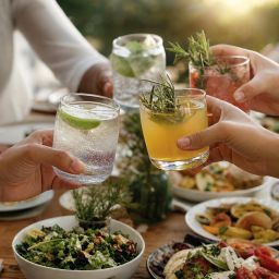 Friends at dinner holding sparkling water and alcohol-free mocktails