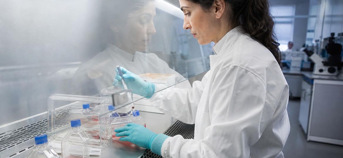 Scientist working at a cell-culture cabinet in a research lab