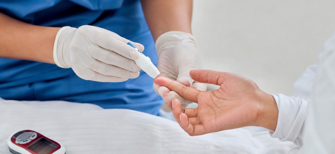 Nurse doing a finger-prick blood glucose test on a patient