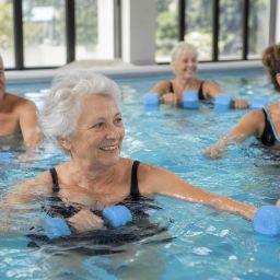 Older adults taking a water aerobics class in an indoor pool