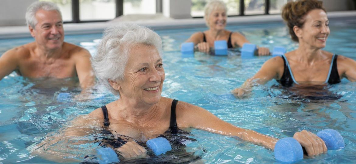 Older adults taking a water aerobics class in an indoor pool