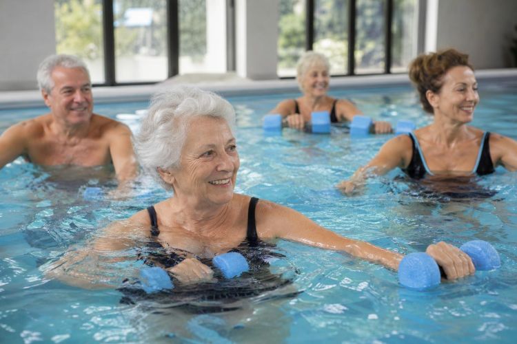 Older adults taking a water aerobics class in an indoor pool