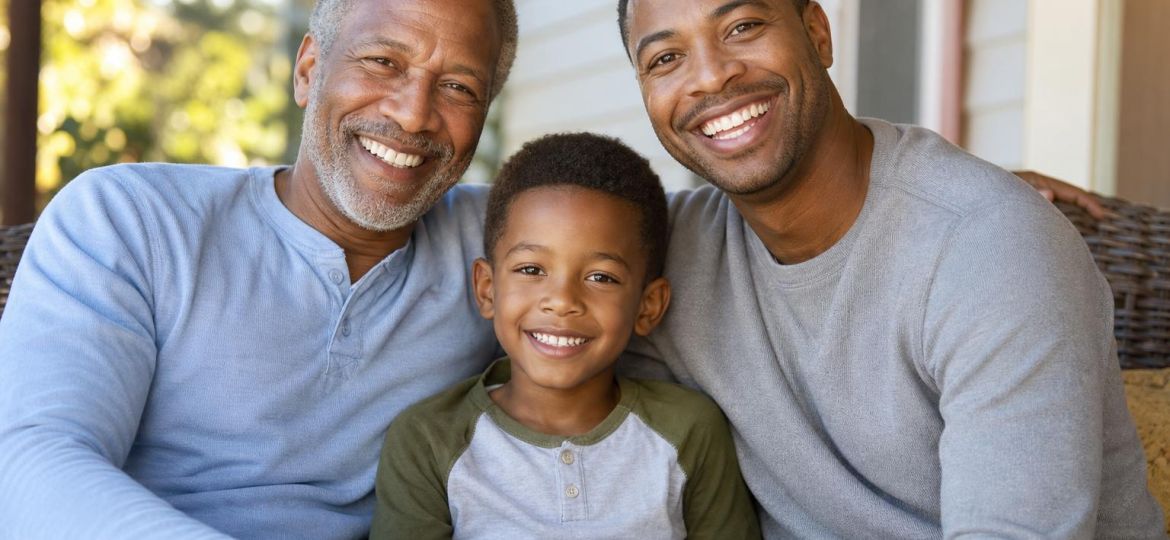 Grandfather, father and son sitting together on a porch