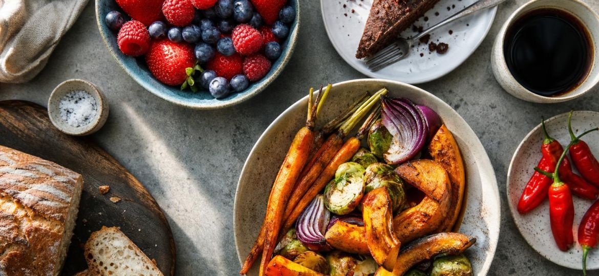 Variety of foods including berries, chocolate cake, roasted vegetables, coffee and chili peppers