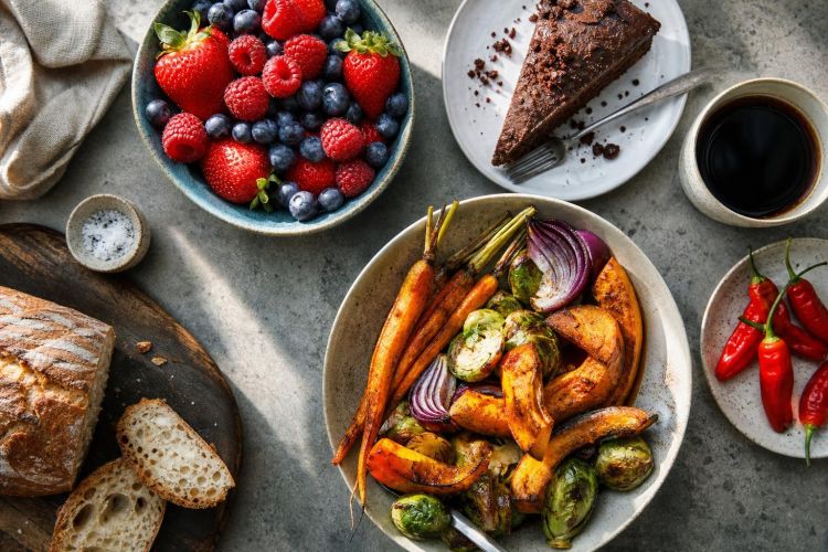 Variety of foods including berries, chocolate cake, roasted vegetables, coffee and chili peppers
