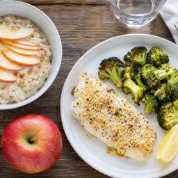 Heart-healthy meal of baked cod, roasted broccoli and oatmeal with apple slices