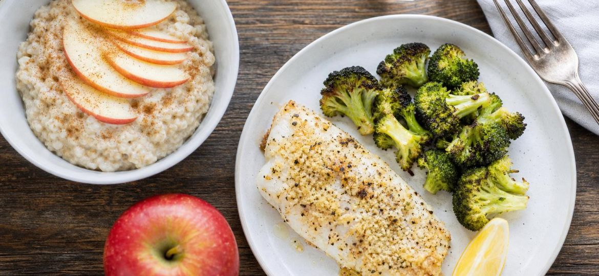 Heart-healthy meal of baked cod, roasted broccoli and oatmeal with apple slices