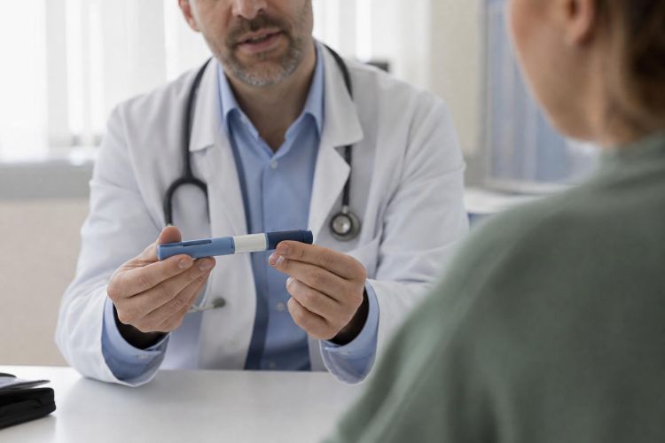 Doctor showing a medication injection pen to a patient