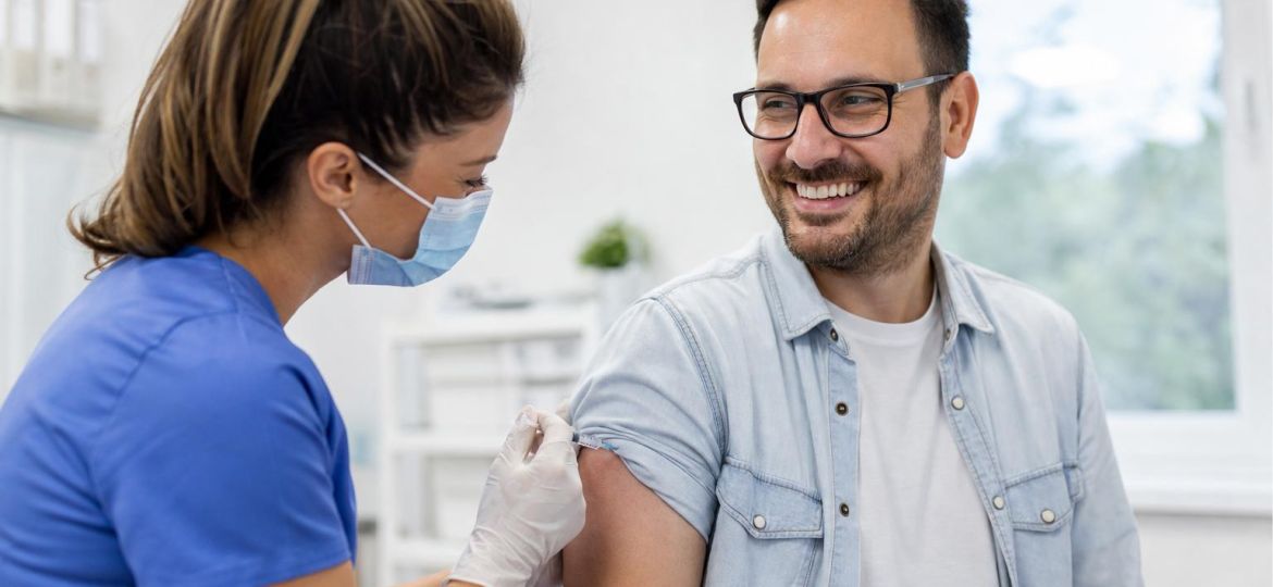 Nurse giving a vaccine shot in a man's upper arm