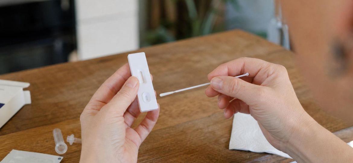 Hands using a rapid at-home antigen test with a nasal swab