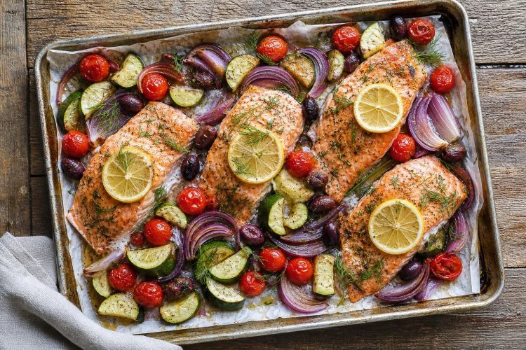 Sheet-pan salmon fillets with lemon, cherry tomatoes, zucchini and olives
