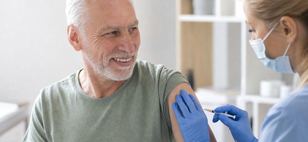 Man in his sixties receiving a vaccine from a nurse