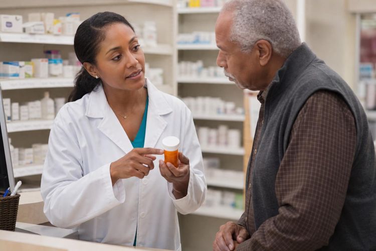 Pharmacist explaining a prescription to an older man at a pharmacy counter